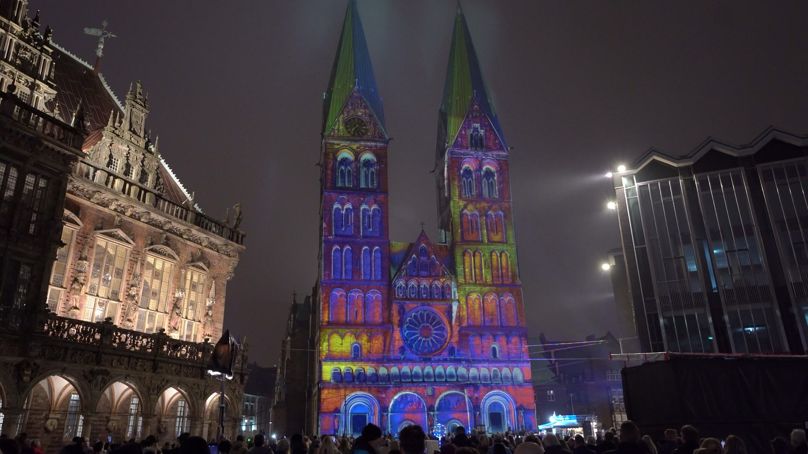 The twin towers of Bremen Cathedral illuminated in blue and gold by a 3D projection mapping at night