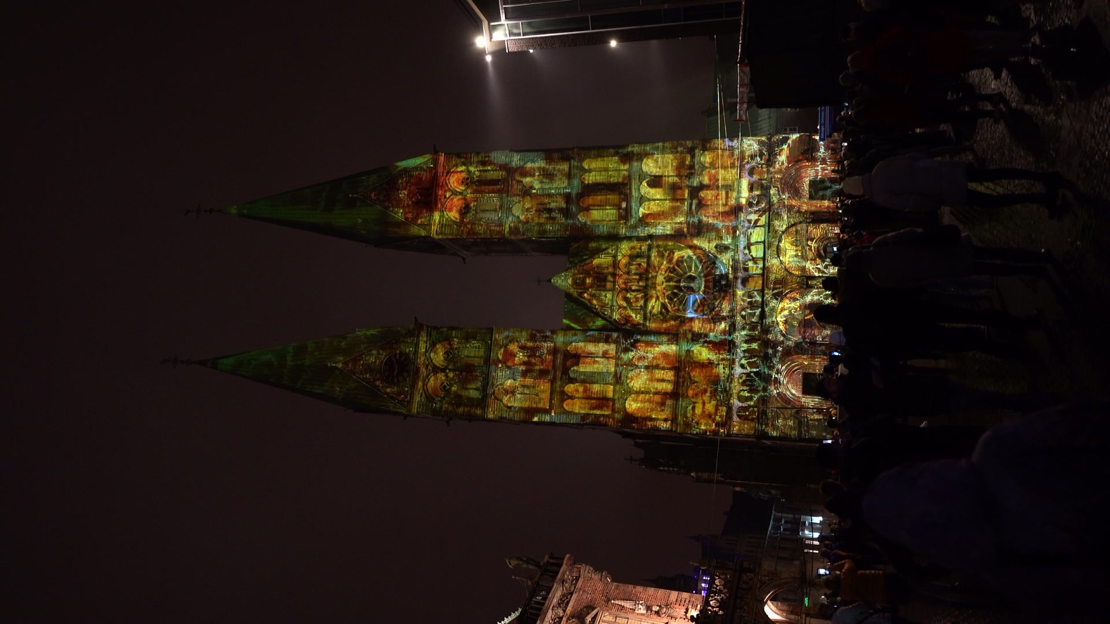The twin towers of Bremen Cathedral illuminated in blue and gold by a 3D projection mapping at night