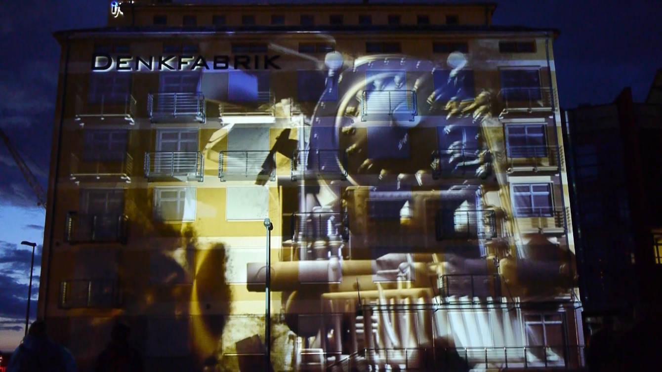 The Denkfabrik building in Magdeburg covered in a projection mapping at night