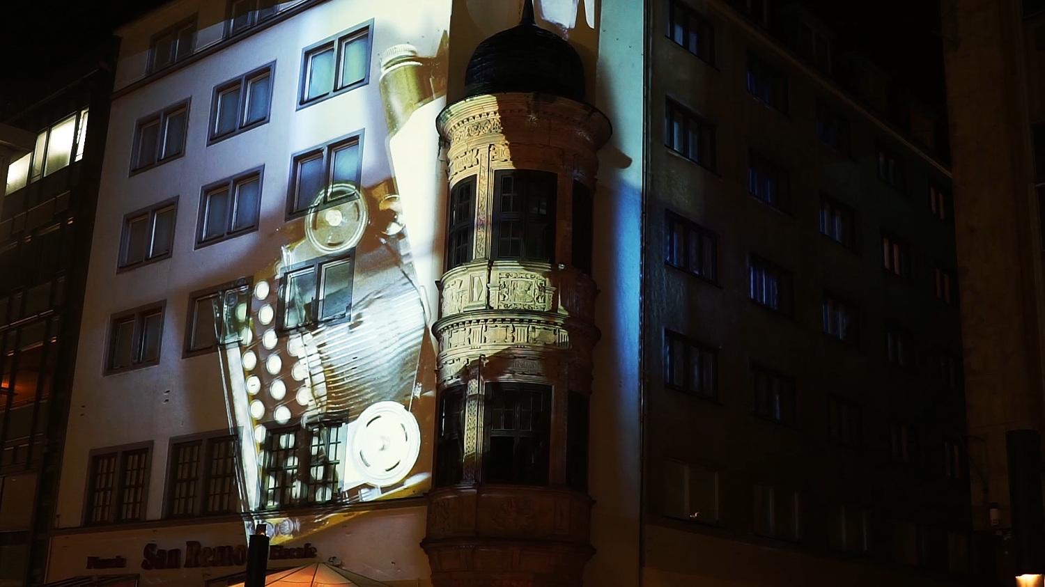 Historic documents and typewritten text projected onto a façade in Leipzig during the Lichtfest