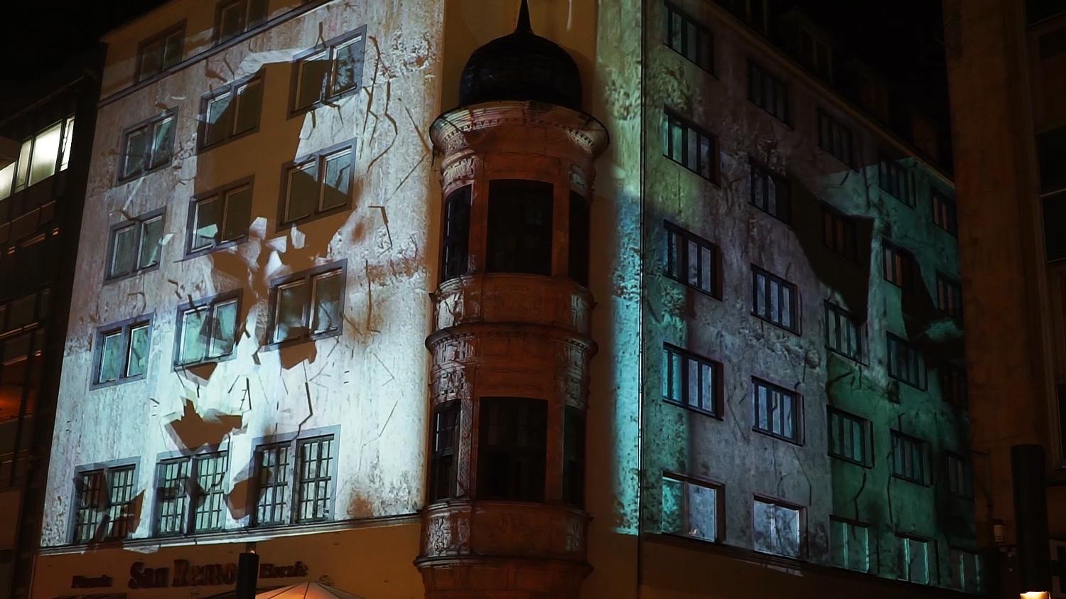 Historic documents and typewritten text projected onto a façade in Leipzig during the Lichtfest