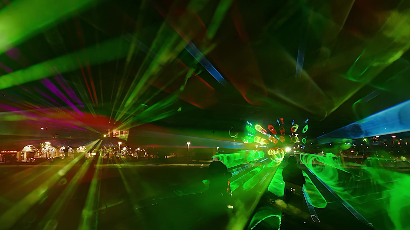 Swirling beams of pink, green and blue light in fog forming a walk-in space at the Marx-Engels-Forum, Berlin, filmed in vertical format