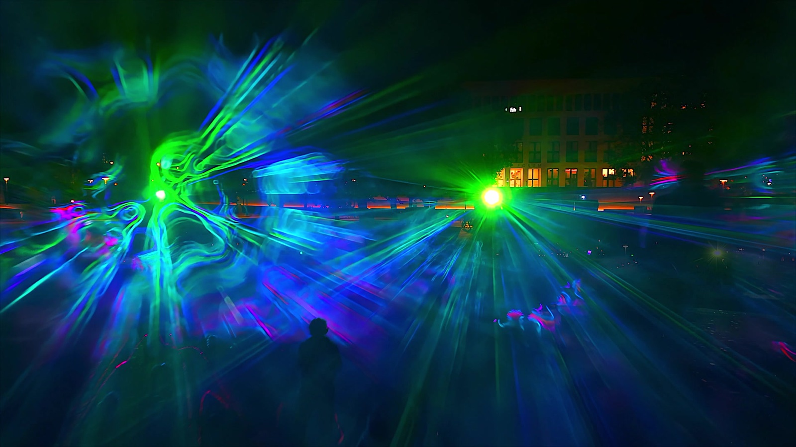 Swirling beams of pink, green and blue light in fog forming a walk-in space at the Marx-Engels-Forum, Berlin, filmed in vertical format