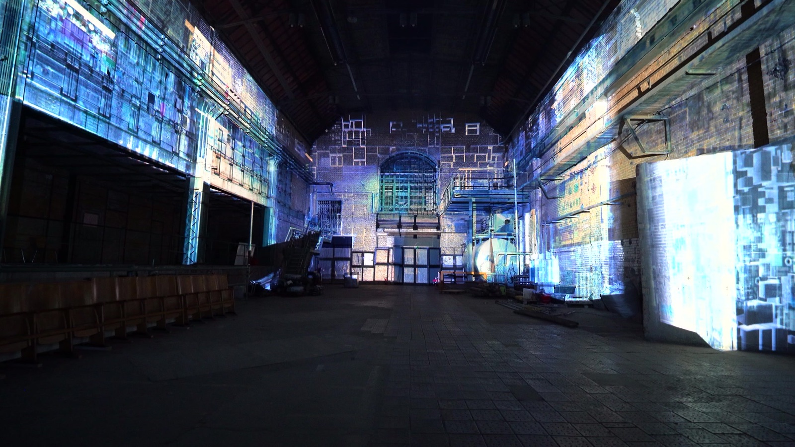 The brick walls of the MaHalla industrial hall in Berlin wrapped in a blue and cyan 270-degree projection mapping