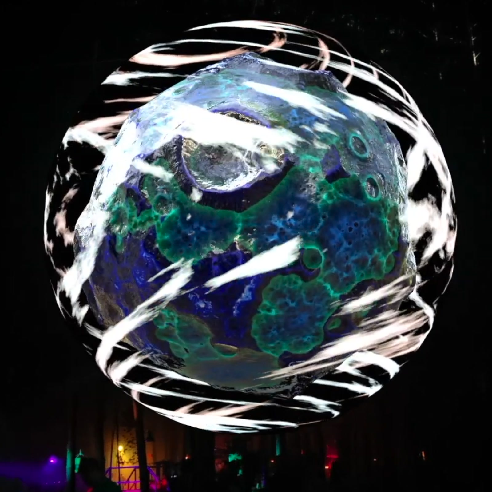 A large sphere standing among trees, covered in a concentric blue projection mapping at Garbicz Festival