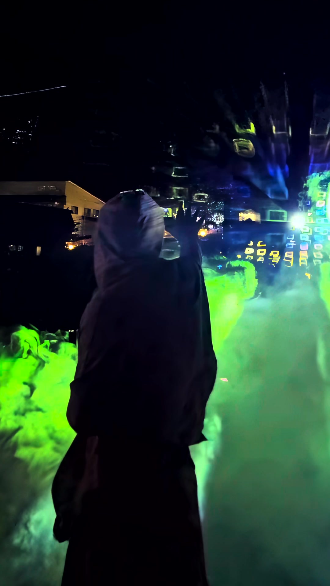 A person standing inside a bright blue holographic light field in fog at night at Re:birth Festival in Japan