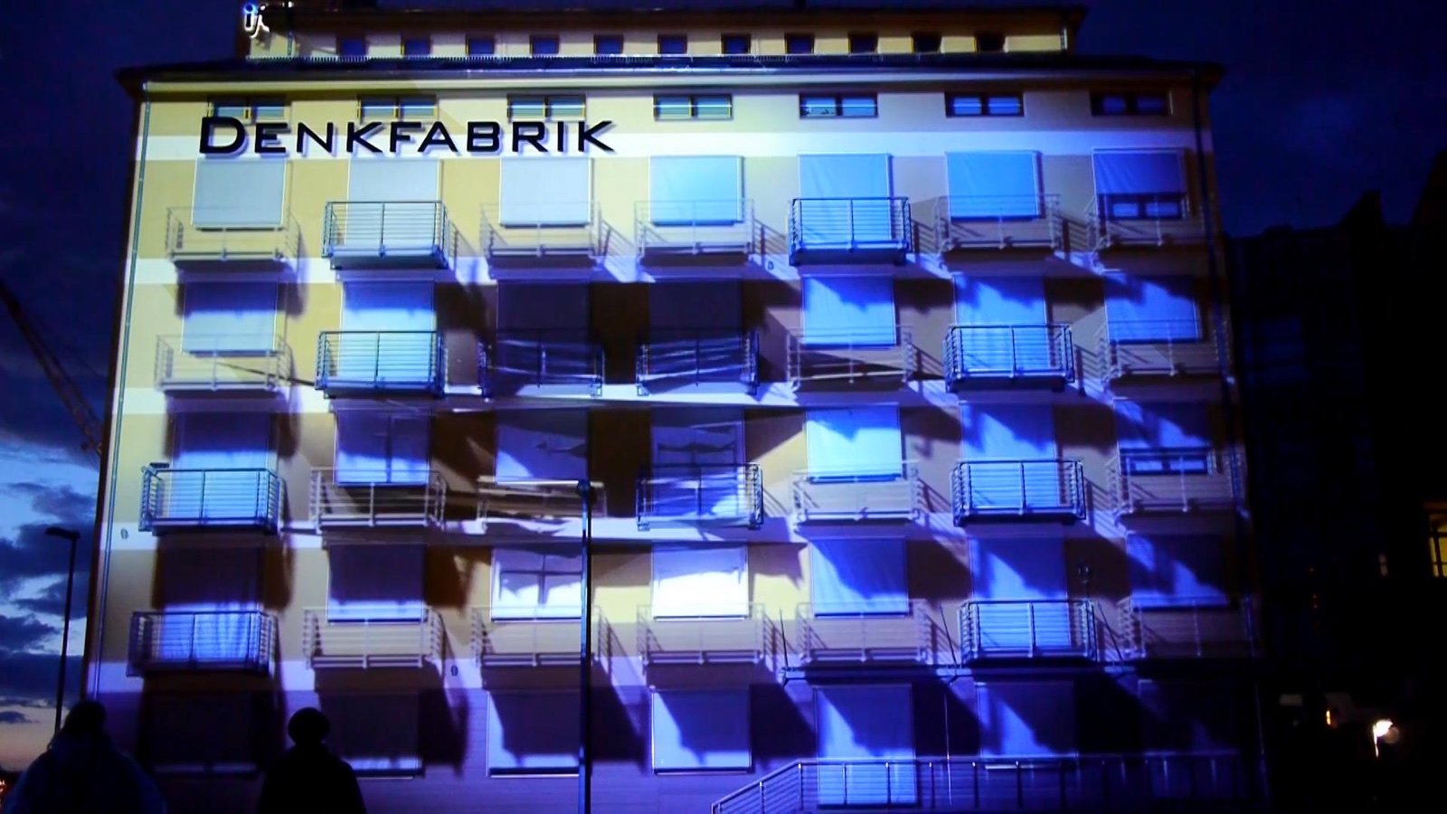 Still from the RE:SORB showreel showing the colourful projection-mapped façade of an opera house