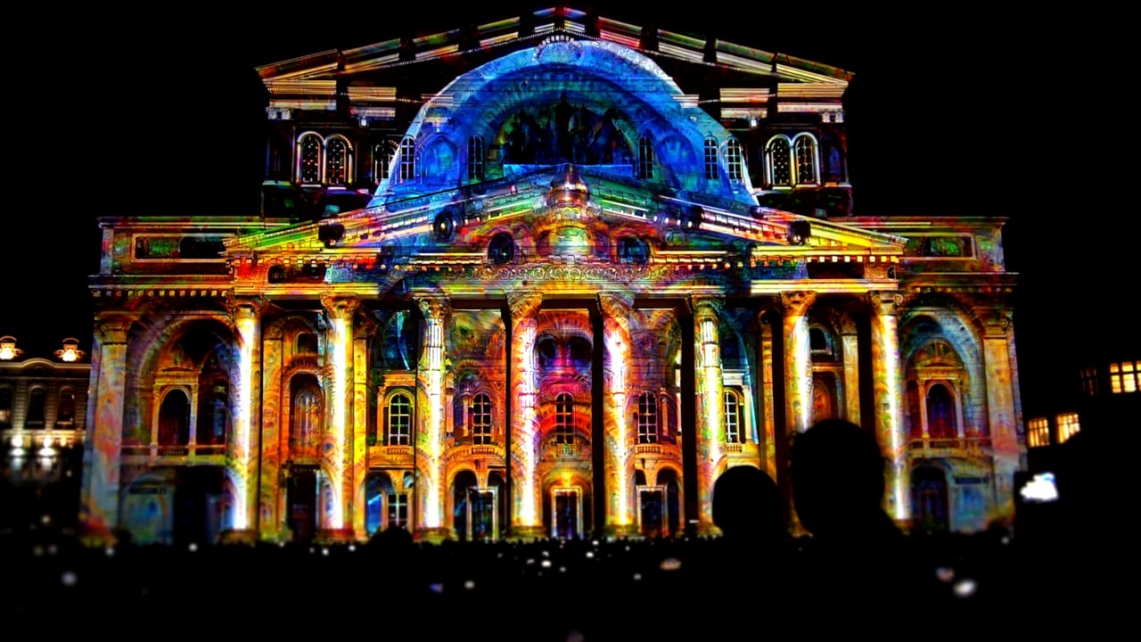 Still from the RE:SORB showreel showing the colourful projection-mapped façade of an opera house