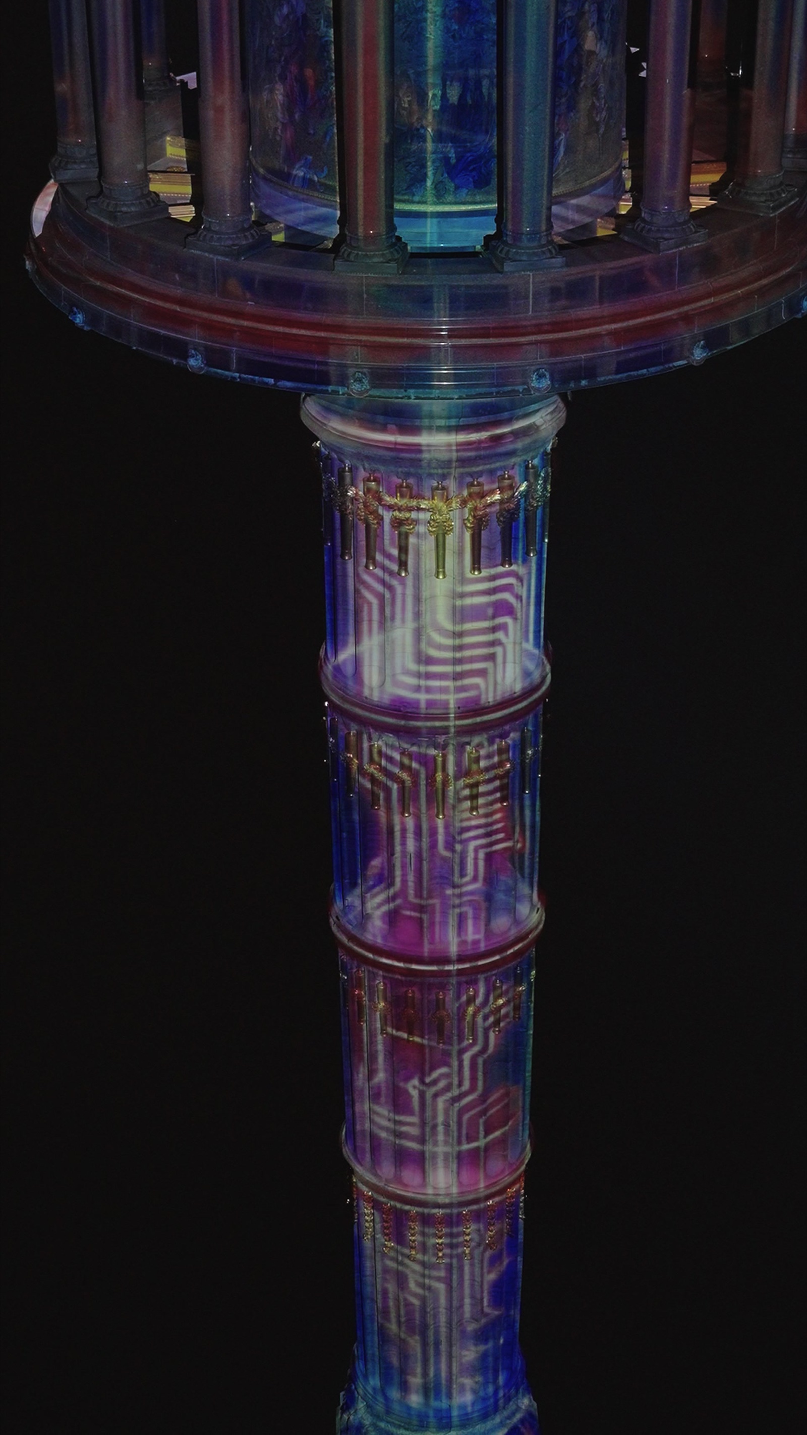 The Berlin Victory Column wrapped in a rainbow-coloured 360-degree projection mapping at night, filmed from below