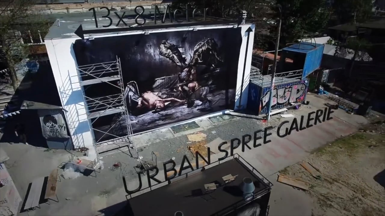 A large mural of an open hand on a building wall, animated with projection mapping