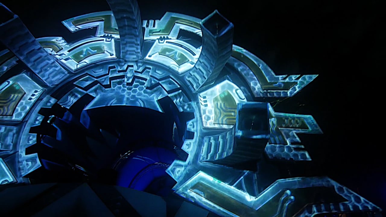 A festival main stage structure at night covered in a blue geometric 3D projection mapping